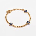 Pulsera en oro 18k. amarillo, rollo con 3 Ojos Turcos Azules.